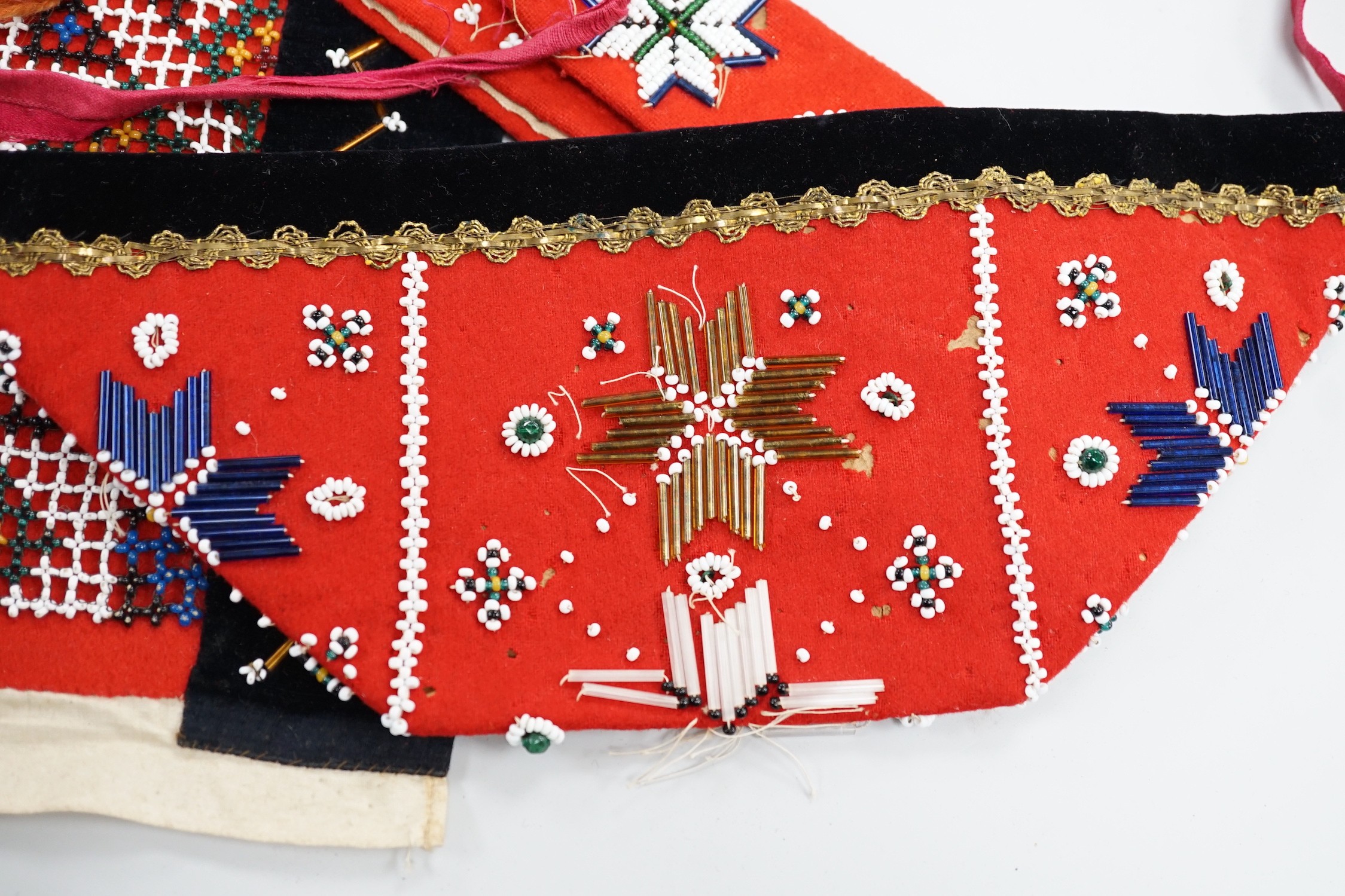 A collection of 19th century Scandinavian beadwork, worked in white and coloured geometric designs on red wood backing, (5)